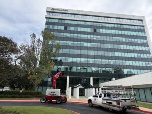 Universal Glass lift truck replacing commercial window glass on a high-rise office building in Mobile, AL